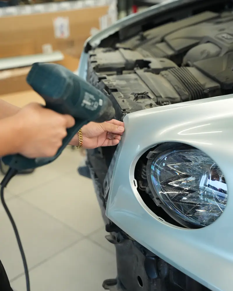 Heat gun used to set the wrap film along the headlight edge of a Bentley Bentayga