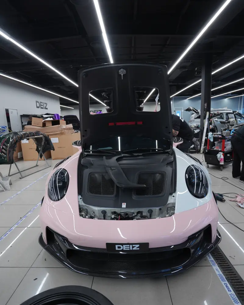 Porsche 911 being prepared for wrapping at DEIZ, bonnet open