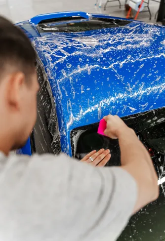 Roof of a blue Lamborghini Huracán being decontaminated before film installation